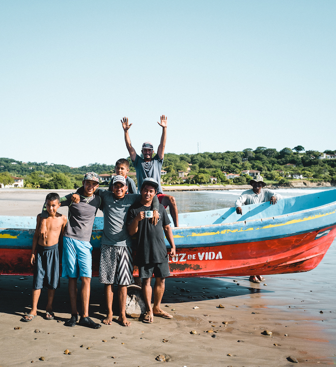 A group of local Nicaraguans pose with a fishing boat and Fara Coffee