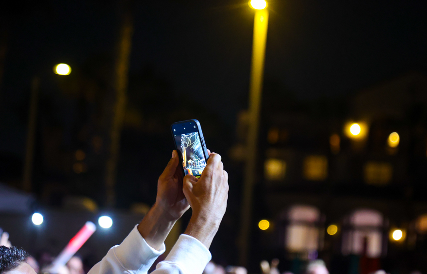 An attendee films a musical performance at FutureProof