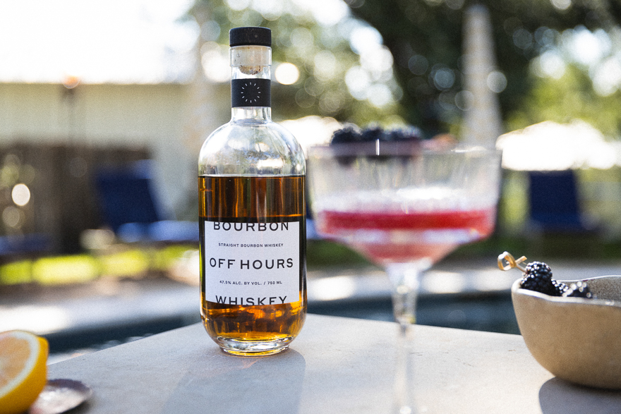 A bottle of Off Hours Whiskey by the pool