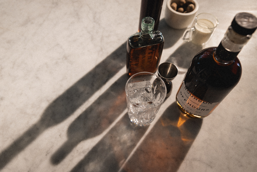 Cocktail ingredients on a kitchen counter with sunlight gleaming through