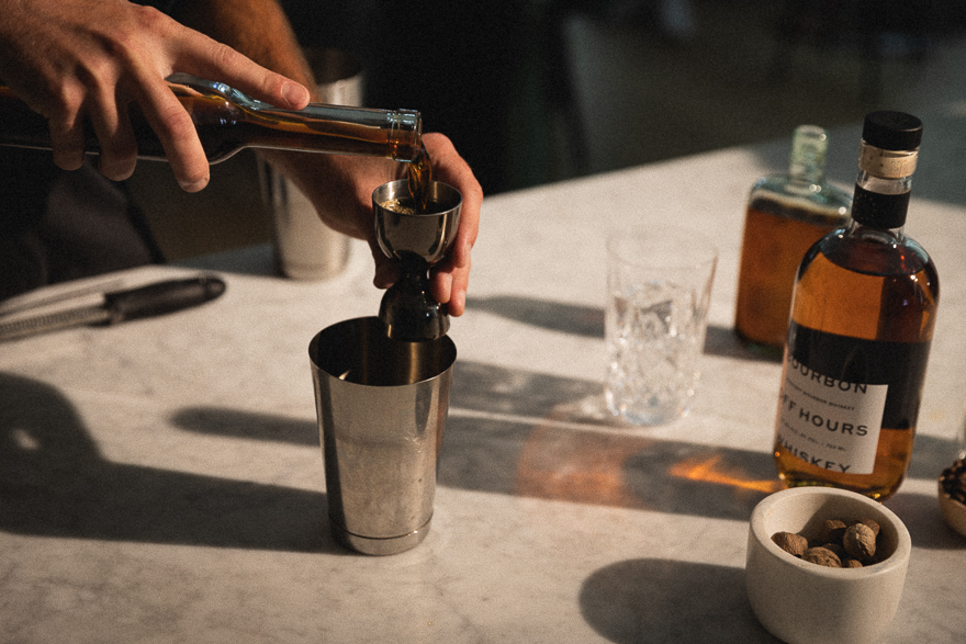 A man mixing a cocktail with Off Hours Whiskey