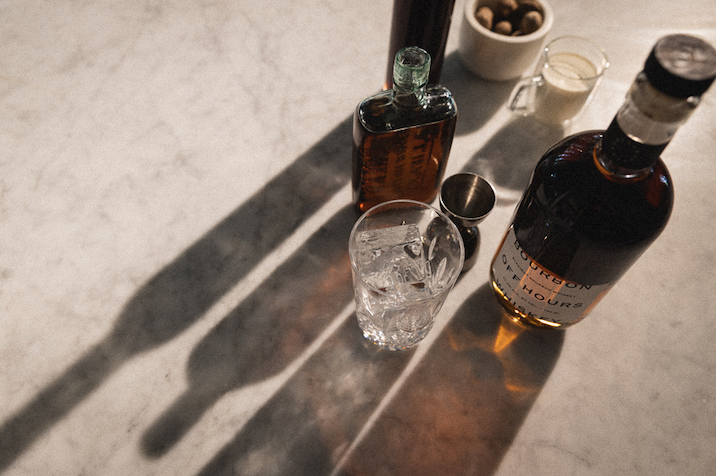 A bottle of Off Hours Whiskey, with ingredients to make a cocktail