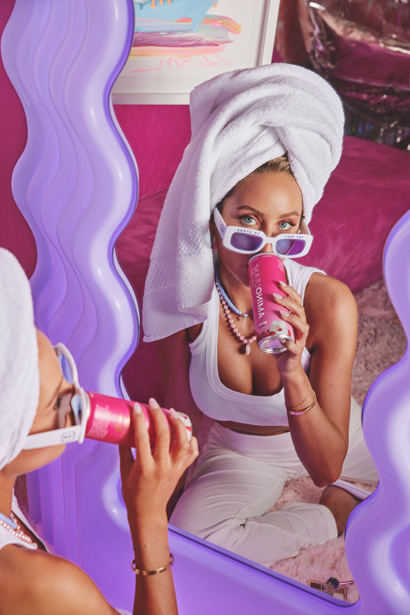 Alix Earle posing with Aminolean pre-workout and her hair in a towel
