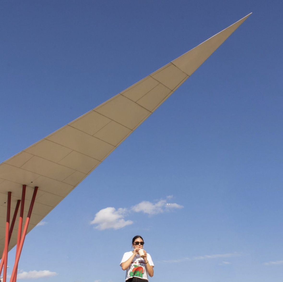 A girl drinking a milkshake in front of iconic P. Terry's architecture