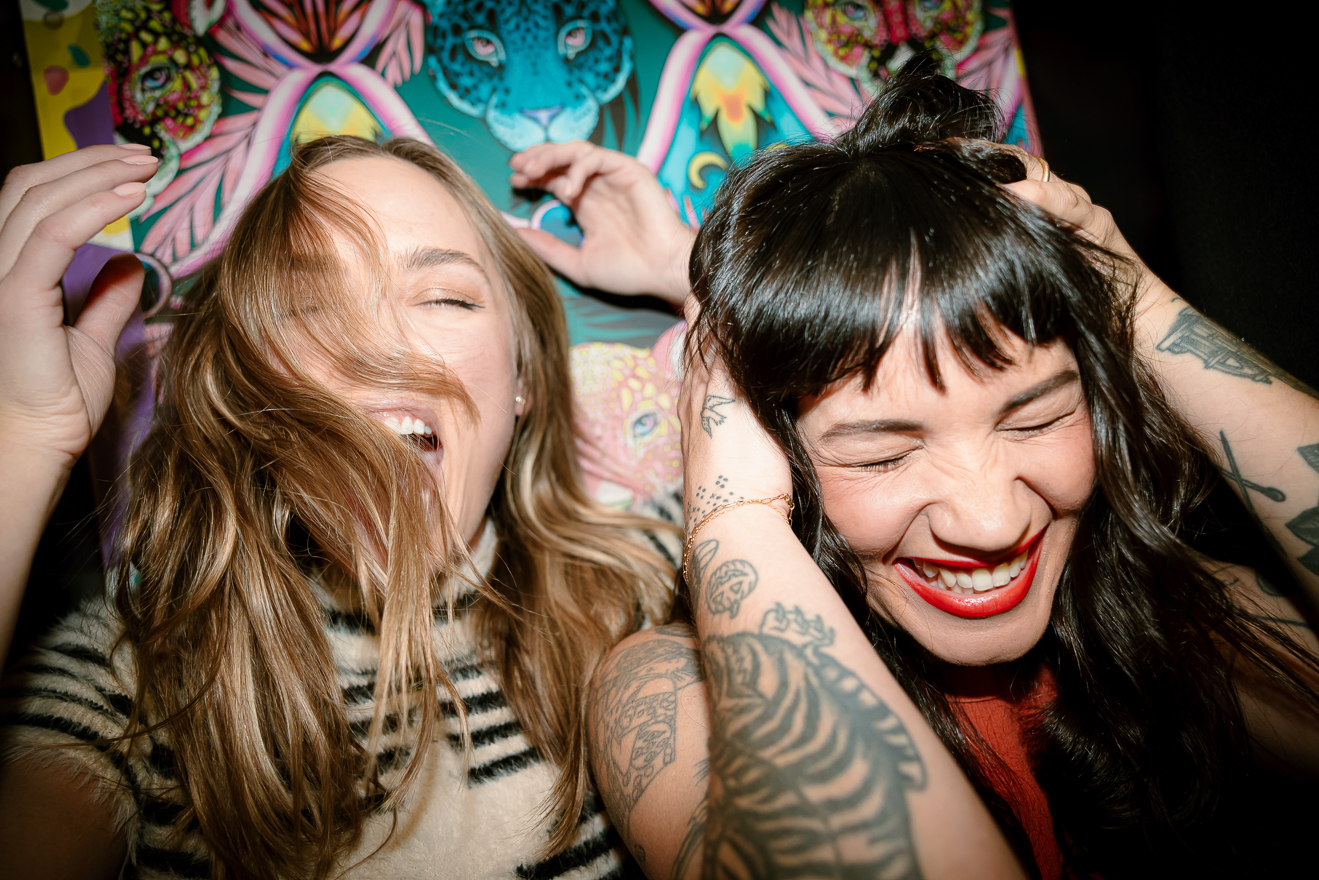 Two women take a silly photo in a photo booth