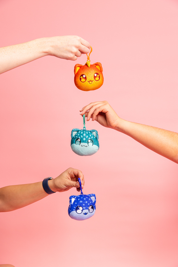 Hands holding small Catface plush toys