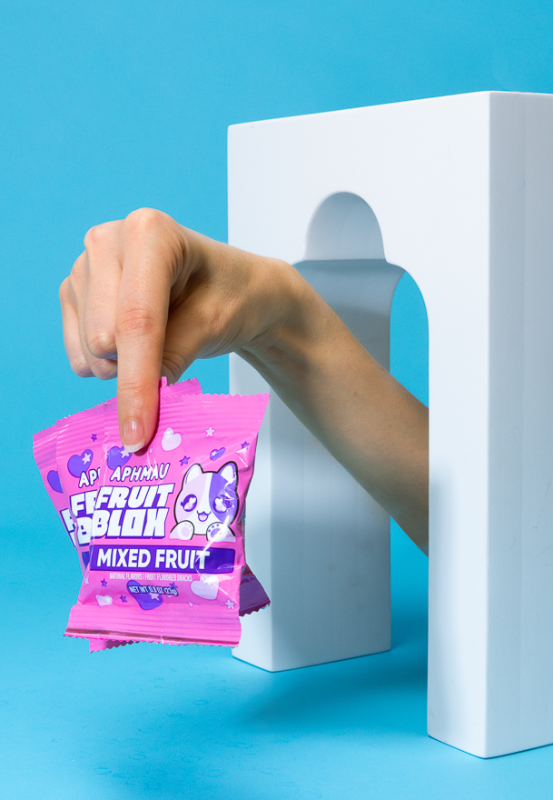 A hand reaching through a portal holding a bag of Catface juiceblox gummies