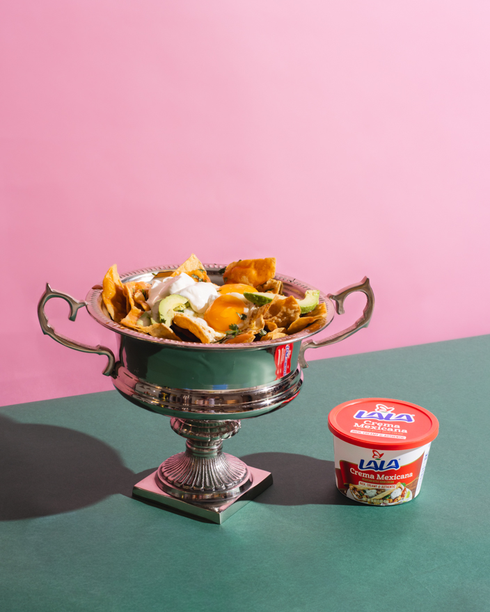 Nachos inside a trophy topped with Lala crema Mexicana