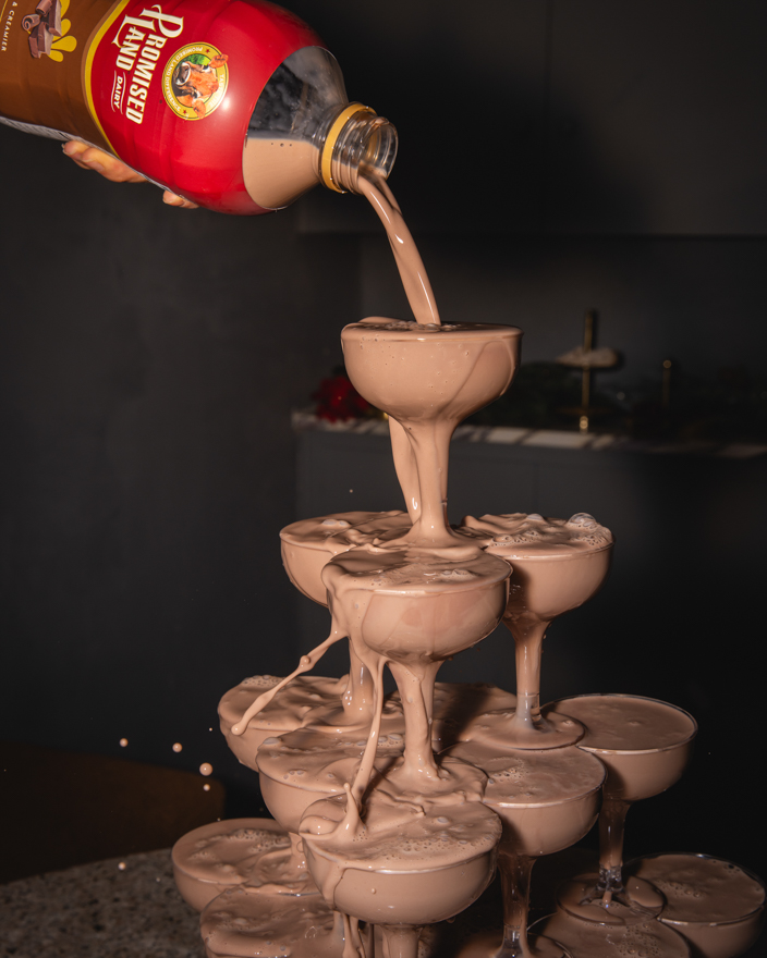 A chocolate milk tower with champagne glasses and Promised Land Dairy chocolate milk