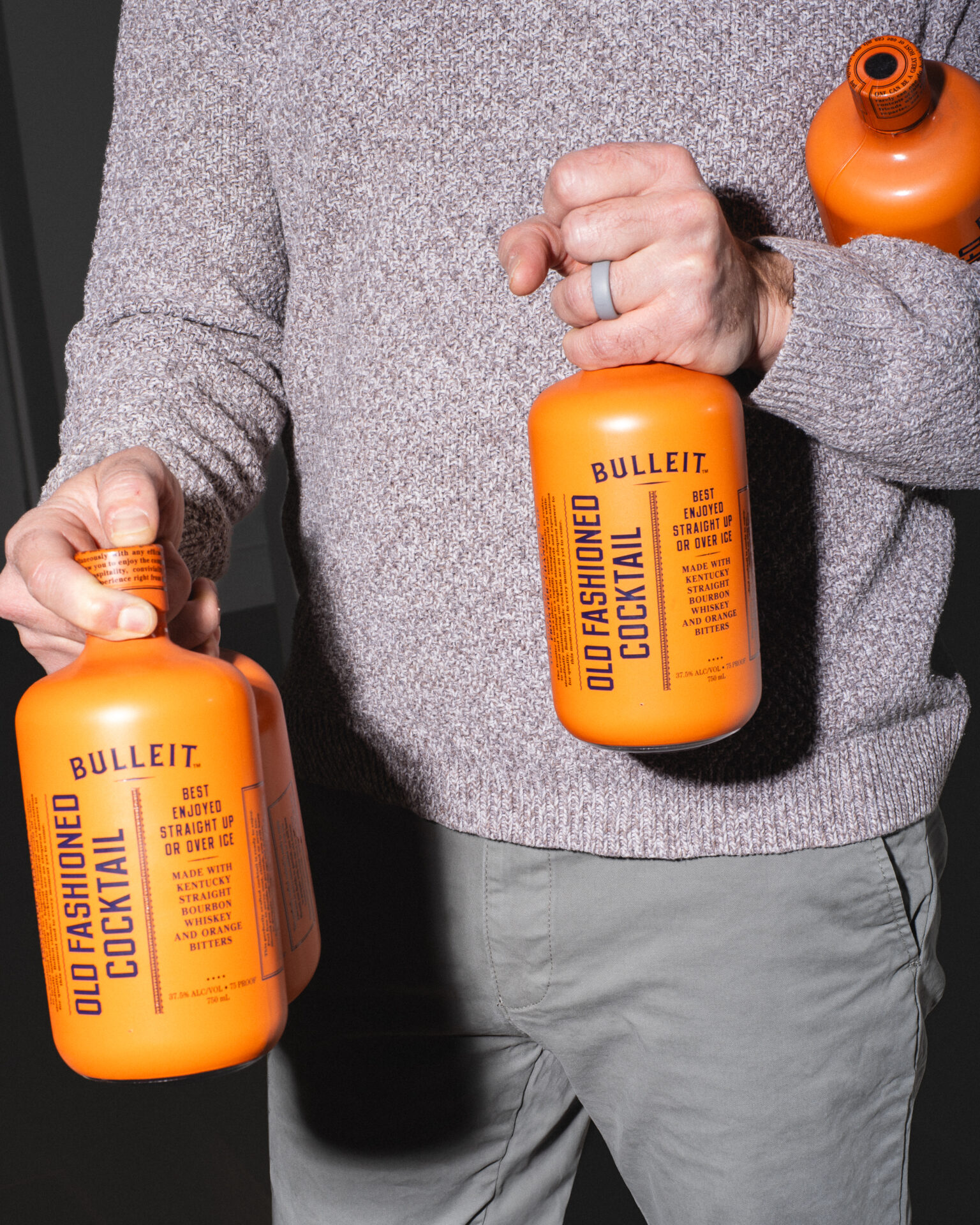A man carrying two bottles of The Cocktail Collection into a party