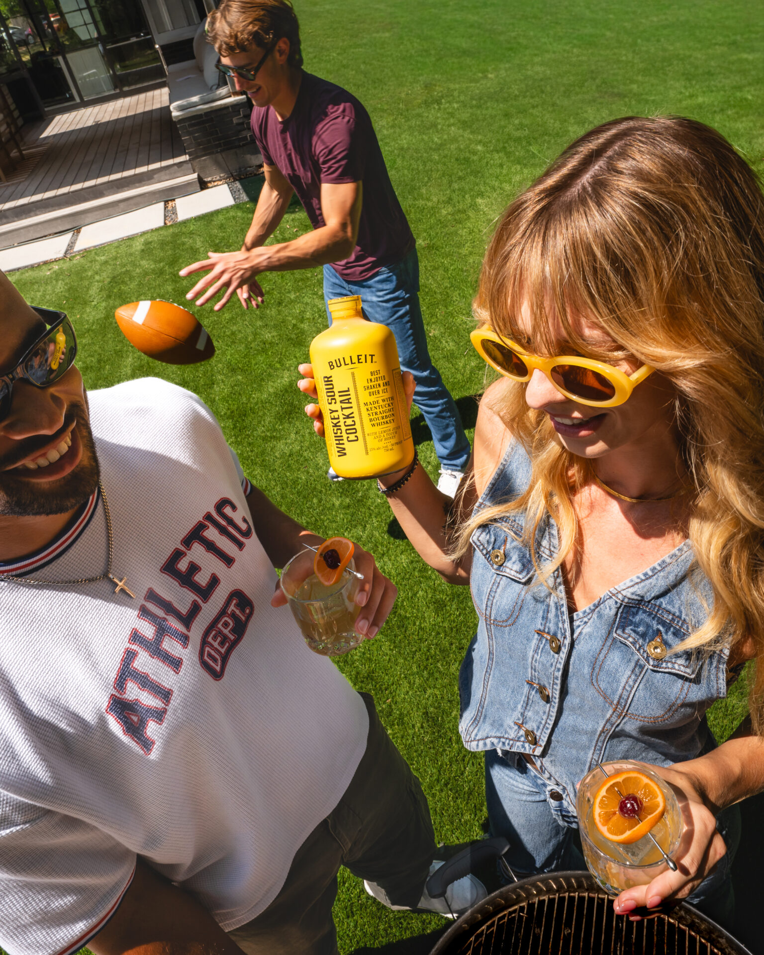 A backyard party with friends holding The Cocktail Collection drinks
