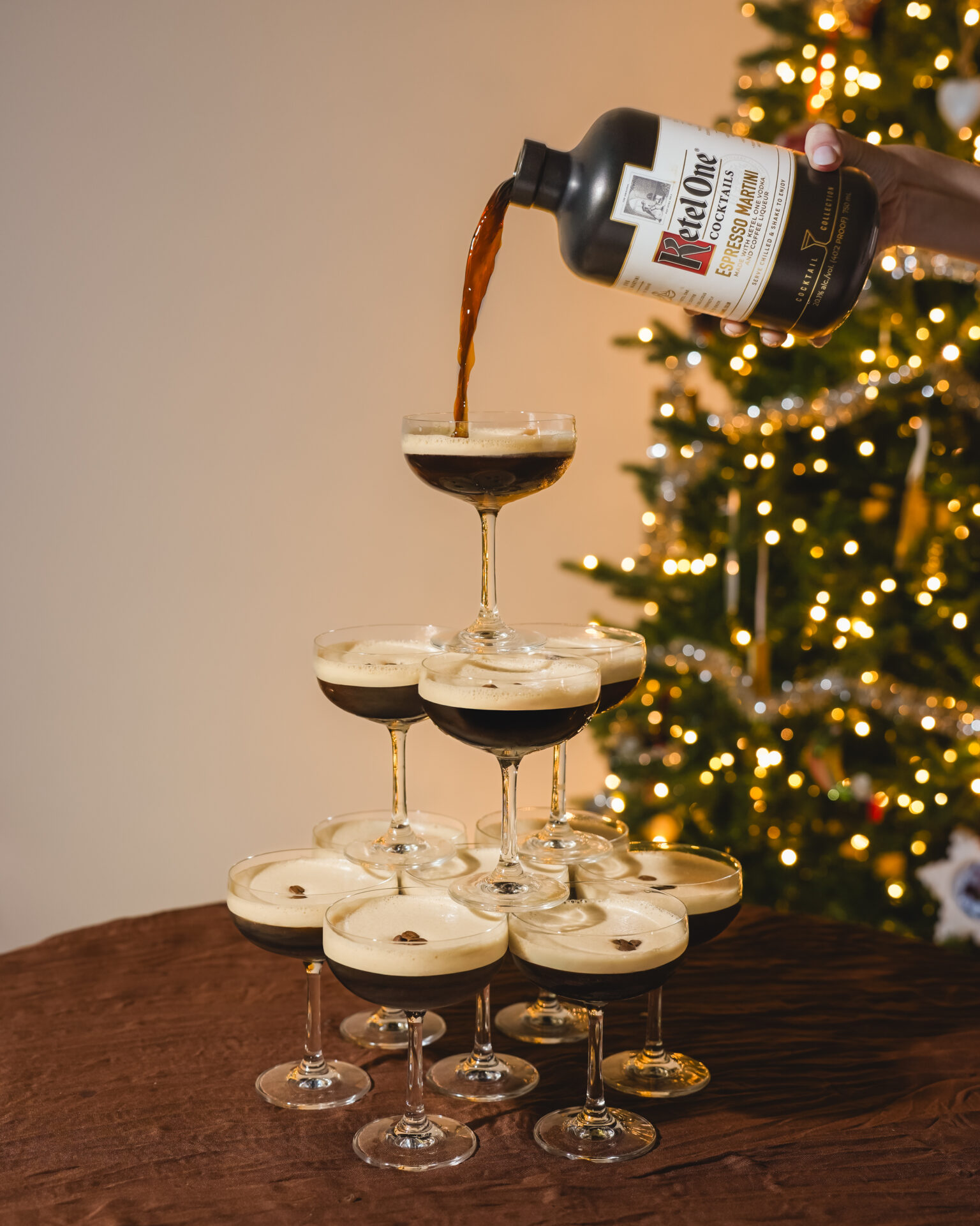 A tower of Ketel One espresso martinis with a Christmas tree in the background