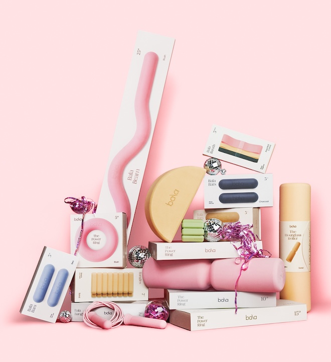 A stack of Bala products, loosely resembling a Christmas tree, against a pink backdrop